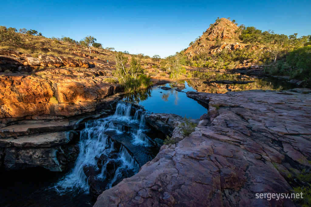 A cute little waterfall (with a cute little person walking down the slope).